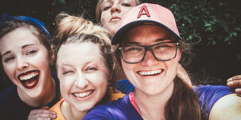 A joyful group of women taking a selfie outdoors, showcasing happiness and friendship.