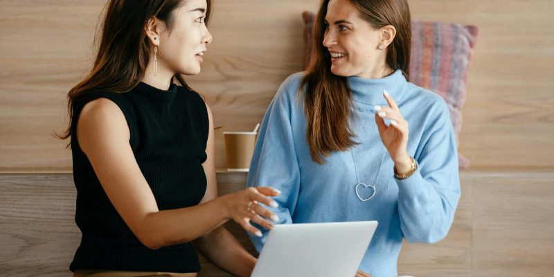 Young multiethnic business partners speaking about strategy of job while browsing netbook in contemporary workplace